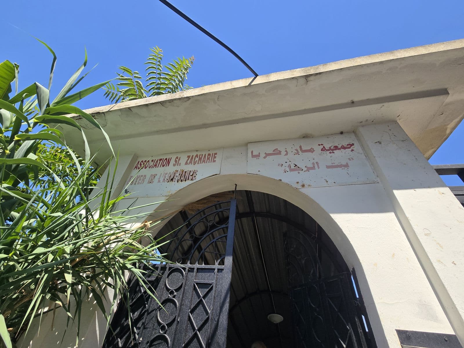 L’arche d’entrée du Foyer, qui porte le nom « Association St Zacharie » en français et en arabe.