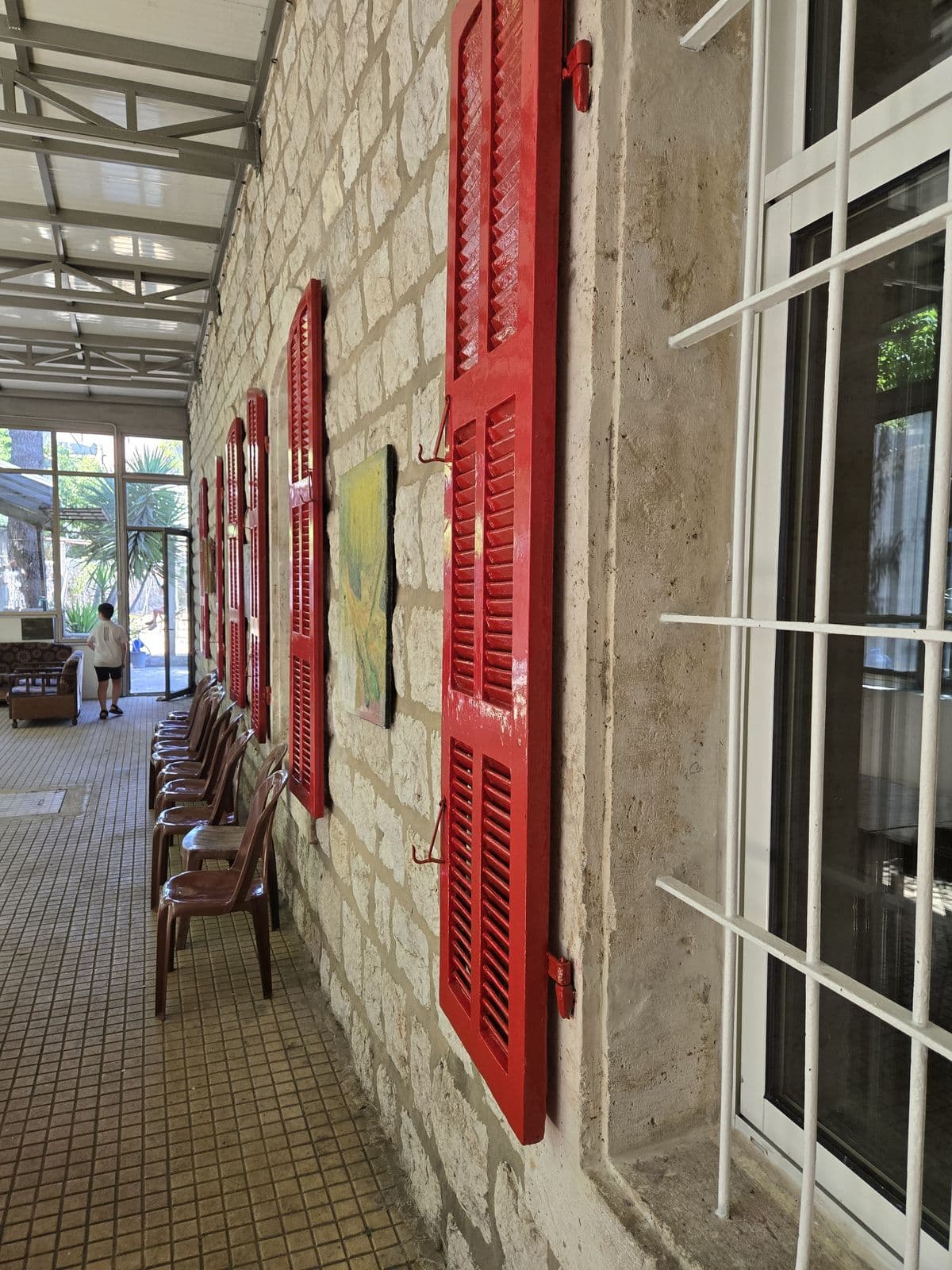 The Home’s long gallery, with stone walls and red shutters.