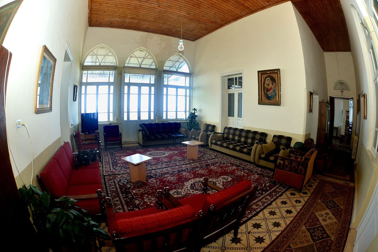 The Home’s large living room, with arched windows and red sofas.